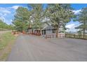 Long driveway leading to a charming gray house nestled among mature trees, offering privacy at 25601 Centennial Trl, Golden, CO 80401