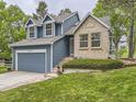 Lovely two-story home with blue siding and a brick facade, complimented by a green lawn and established landscaping at 11523 Sandy Creek Ln, Parker, CO 80138