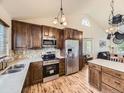A spacious kitchen featuring wooden cabinetry, stainless steel appliances, tile backsplash, and bright, vaulted ceilings at 11523 Sandy Creek Ln, Parker, CO 80138