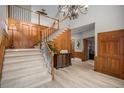 Grand foyer with wood paneling, staircase, and light hardwood floors that leads to a separate office at 5442 S Dayton Ct, Greenwood Village, CO 80111