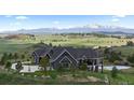 Beautiful home with a water feature, set against a backdrop of majestic mountains and green hills at 15295 E Cherry Creek S Rd, Larkspur, CO 80118
