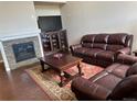 Inviting living room featuring a fireplace, entertainment center, and comfortable leather furniture at 4746 Raven Run, Broomfield, CO 80023