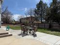 Backyard features a concrete patio with outdoor dining set and mature trees at 2050 Lake Circle Dr, Thornton, CO 80241