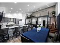 Open-concept dining room adjacent to kitchen with a large table and modern seating, ideal for entertaining at 6360 W 1St Ave, Lakewood, CO 80226
