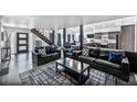 Spacious open-concept living room with hardwood floors, modern decor, and staircase to the upper level at 6360 W 1St Ave, Lakewood, CO 80226