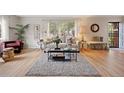Bright living room with large windows, hardwood floors, stylish furniture, and cozy rug at 4580 S Huron St, Englewood, CO 80110