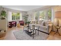 Sunlit living room boasts hardwood floors, neutral decor, large windows, and comfortable seating at 4580 S Huron St, Englewood, CO 80110