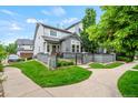 Landscaped home exterior with a well-manicured lawn, patio area, and complemented by mature trees and a welcoming walkway at 3748 Oakwood Dr, Longmont, CO 80503
