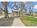 Backyard gazebo style structure with stone pathway and beautiful lawn at 7060 Holly St, Commerce City, CO 80022