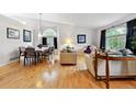 Open-concept living and dining area with hardwood floors, large arched windows, and elegant furnishings at 4819 Jericho Ct, Denver, CO 80249