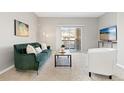 Bright living room with a cozy green sofa, stylish decor, and sliding glass doors to a private balcony at 10052 W Ute Pl # 202, Littleton, CO 80127