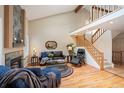 Open-concept living room with high ceilings, fireplace, hardwood flooring, and a staircase to an upper level at 4605 S Yosemite St # 36, Denver, CO 80237