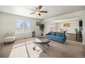 Inviting living room with large window, neutral carpet and an open floorplan with views of the kitchen and dining area at 47356 Lilac Ave, Bennett, CO 80102