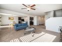 Bright living room featuring neutral carpet, modern ceiling fan and an open floorplan with views of the kitchen and dining area at 47356 Lilac Ave, Bennett, CO 80102
