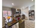 Modern kitchen with stainless steel appliances, unique countertops, breakfast bar, and gray cabinets at 26259 Kingsbury Rd, Kittredge, CO 80457