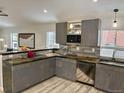 Contemporary kitchen boasts stainless appliances, breakfast bar, wood backsplash, and gray cabinets at 26259 Kingsbury Rd, Kittredge, CO 80457