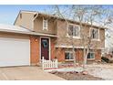 Attractive two-story home featuring a brick facade, white trim, and a welcoming front entrance with wreath at 9240 W Wagon Trail Dr, Littleton, CO 80123