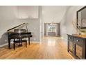 Open living space with hardwood floors, a grand piano, and a dining area at 2517 S Eldridge Ct, Lakewood, CO 80228