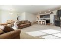 Open concept living room with a kitchen, neutral carpet and large sofa at 2342 Shipman St, Brighton, CO 80603