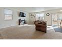 Bright living room with neutral carpet, a TV, and sliding door to outside area at 2342 Shipman St, Brighton, CO 80603