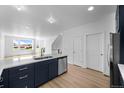 Open kitchen with stainless steel dishwasher and sink, flowing into the dining and living area at 2740 W 68Th Ave, Denver, CO 80221