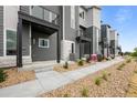 View of newly constructed townhomes with modern architecture featuring a sidewalk and rock landscaping at 2740 W 68Th Ave, Denver, CO 80221