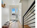 Bright entryway with hardwood floors, a bench, and a modern staircase at 949 Raleigh St # 2, Denver, CO 80204