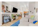 Open-concept living room with fireplace, TV, and view into the kitchen and dining area at 8073 W 51St Pl # 303, Arvada, CO 80002