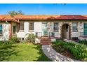 Charming home featuring a red tile roof, arched entrance, and well-maintained front lawn at 1422 Ivy St, Denver, CO 80220