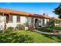 Charming home featuring a red tile roof, arched entrance, with a well-maintained lawn and landscaping at 1422 Ivy St, Denver, CO 80220