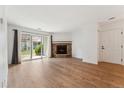 Open-concept living room with stone fireplace and sliding glass doors for natural light at 3600 S Pierce St # 1-104, Lakewood, CO 80235