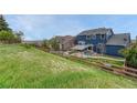 Expansive backyard featuring lush greenery, a wooden fence, and a partial view of the home's exterior at 3367 Dove Valley Pl, Castle Rock, CO 80108