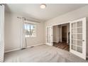 Bright bedroom featuring a large window and french doors at 6612 S Muscadine Ct, Aurora, CO 80016