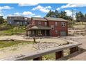 Beautiful multi-story home with a covered porch and a well-manicured landscape at 826 Meadow Ln, Palmer Lake, CO 80133