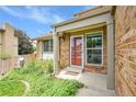 Inviting front porch with a red door and well-maintained landscaping at 11149 Seton Pl, Westminster, CO 80031