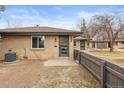 Well-maintained brick home with a cozy, fenced front yard, a modern door, and fresh landscaping at 2800 N Harrison St, Denver, CO 80205