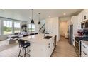 Open-concept kitchen featuring stainless steel appliances, quartz counters, and island with seating at 8982 Spaulding St, Parker, CO 80134