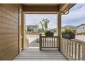 Covered front porch features wood plank flooring, railings, columns, and neighborhood views at 8982 Spaulding St, Parker, CO 80134