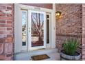 Elegant front door featuring sidelights, brick facade, and stylish address numbers at 6406 Eagle Ct, Longmont, CO 80503