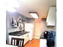 White kitchen features black countertops and wood floors at 2375 S Linden Ct # 104, Denver, CO 80222