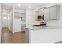 Modern kitchen features gray cabinets, stainless appliances, granite countertops, and an island at 6500 13Th St, Frederick, CO 80530