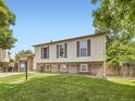 Charming two-story home with vinyl siding, brick accents, landscaped lawn, and an attached garage at 11062 Hudson Ct, Thornton, CO 80233