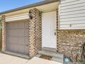Inviting front entrance with brick accents, a well-lit porch, and an attached garage at 11062 Hudson Ct, Thornton, CO 80233