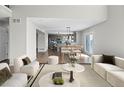 Open-concept living area showcasing hardwood floors, modern furniture, and a view of the dining area and kitchen at 8414 Bed Straw St, Parker, CO 80134