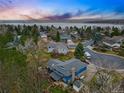 Breathtaking aerial view of a blue house nestled among lush greenery and a serene lake in the background at 3053 Mcintosh Dr, Longmont, CO 80503