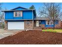 Charming two-story home with blue siding, brick accents, an attached garage, and a beautifully landscaped front yard at 3053 Mcintosh Dr, Longmont, CO 80503