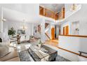 Bright, open-concept living and dining area with hardwood floors and a staircase at 10047 Sylvestor Rd, Highlands Ranch, CO 80129