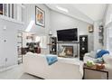 Bright living room featuring a fireplace, vaulted ceilings, and a dedicated office space at 5027 E Barrington Ave, Castle Rock, CO 80104
