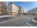 Well-maintained townhome complex with gray siding, stone accents, and individual garages in a desirable neighborhood at 2769 W Riverwalk Cir # E, Littleton, CO 80123