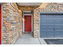 Charming entrance with a red front door, brick accents, and an attached garage, creating a welcoming curb appeal at 2769 W Riverwalk Cir # E, Littleton, CO 80123